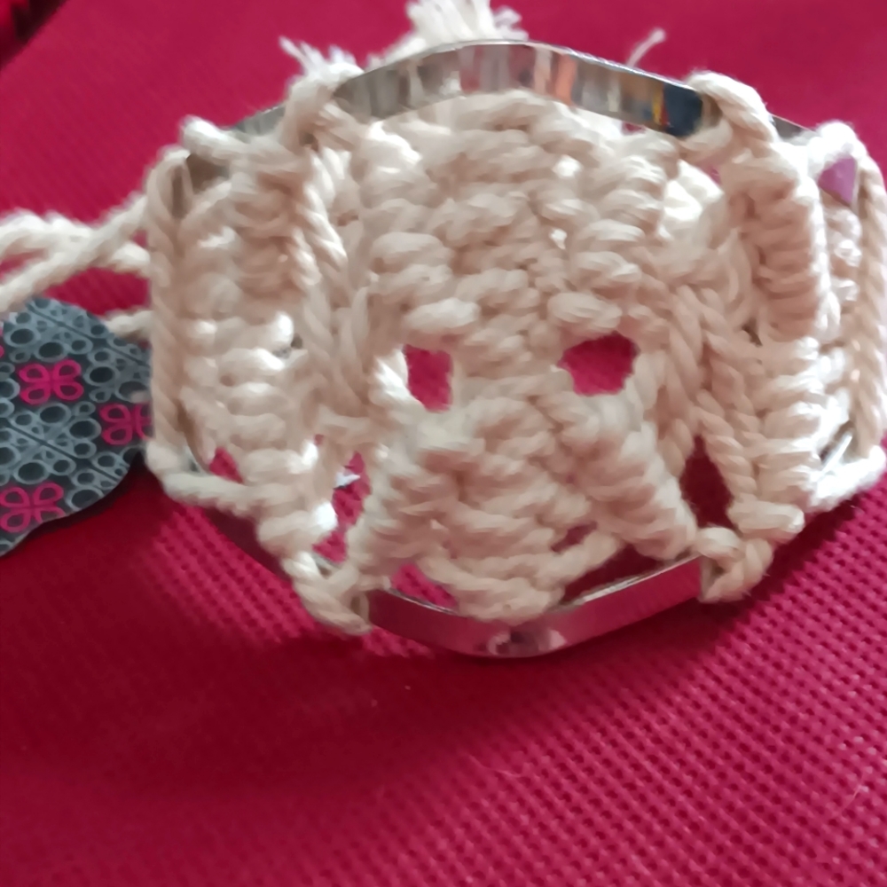 Macromae and metal bracelet off white in color.